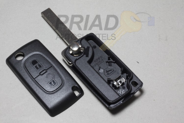 Peugeot 2-knops klapsleutel behuizing met batterij achterkant en sleutelbaard met groef.