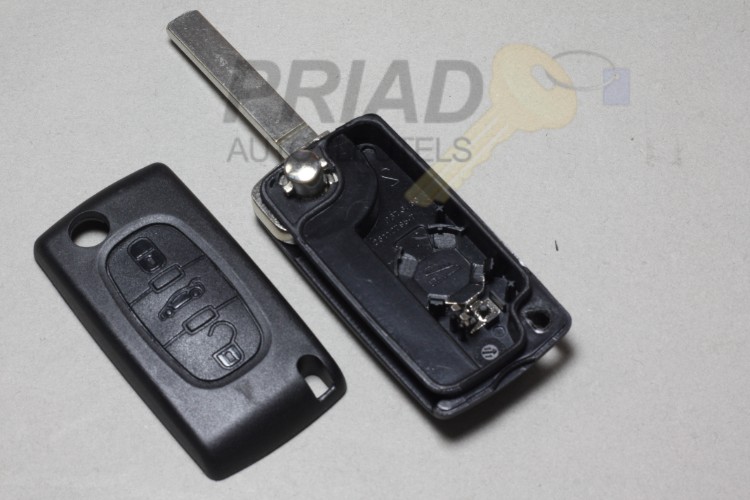 Peugeot 3-knops klapsleutel behuizing met batterij achterkant en sleutelbaard zonder groef.